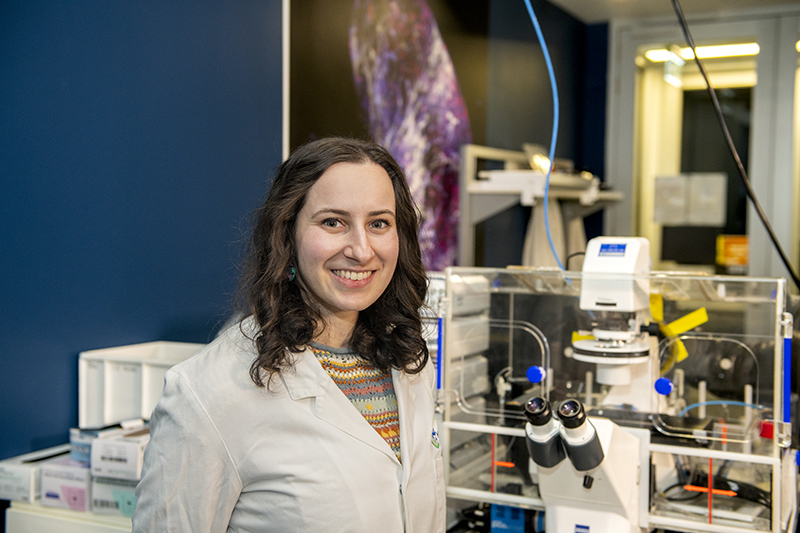 Portrait of Sabrina Lewis in the Imaging Lab, in front of microscope 